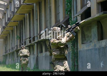 Soldato in guerra civile, edificio in rovina. Battaglia di quarto chiuso e concetto di guerra civile. Foto Stock