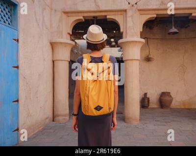 Gita turistica alla vecchia Dubai, Emirati Arabi Uniti. Asian Woman turista in vecchie stradine strette di Bur Dubai e Creek, al Seef Heritage Souq. Concetto di viaggio e di viaggio turistico Foto Stock