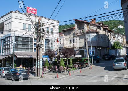 Una massa aggrovigliata di cavi elettrici e cavi di alimentazione attaccati a un palo d'angolo della strada si è saltata l'una sull'altra a Prizren, Kosovo, ex Jugoslavia Foto Stock