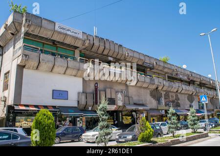 Caratteristiche dall'esterno e dalla facciata di un centro commerciale a Tetovo, Macedonia del Nord, costruito in architettura brutalista nella Jugoslavia comunista. Foto Stock