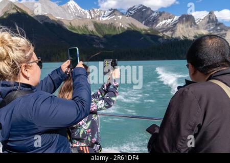 Jasper, Alberta, Canada - 13 luglio 2022: I turisti sulla crociera in barca di Spirit Island scattano foto del bellissimo paesaggio delle Montagne Rocciose canadesi Foto Stock