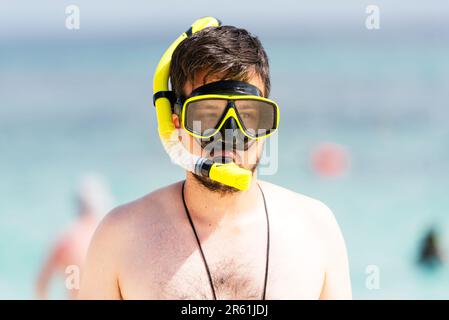 Giovane uomo con attrezzatura da snorkeling in spiaggia. Foto Stock