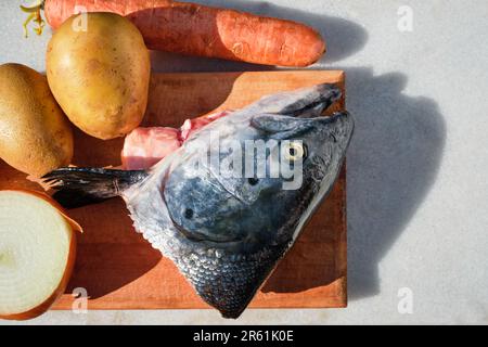 Ingredienti per preparare zuppa di pesce di salmone su un tavolo di marmo e tagliere. Verdure e ortaggi a radice fresca per Lohikeitto Foto Stock