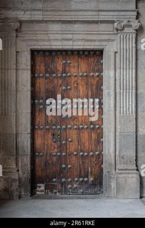 Una verticale di una vecchia porta in legno con rivetti e viti metalliche Foto Stock