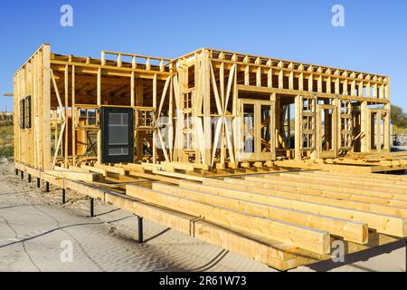 Nuovo edificio incompiuto di caffè in legno naturale e pavimento in terrazza sulla costa baltica, sfondo cielo blu Foto Stock