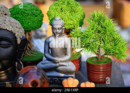 Bella statuetta fatta a mano di Buddha Signore è esposta in un negozio in vendita su sfondo sfocato. Arte indiana e artigianato. Foto Stock