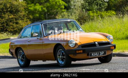 Stony Stratford, Regno Unito - Giugno 4th 2023: 1975 MGB GT auto classica in viaggio su una strada di campagna inglese. Foto Stock