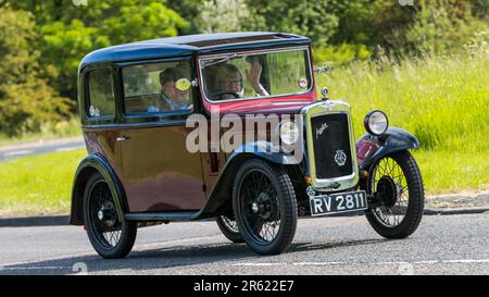 Stony Stratford, Regno Unito - 4th 2023 giugno: 1932 AUSTIN SETTE auto d'epoca in viaggio su una strada di campagna inglese. Foto Stock