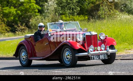 Stony Stratford, Regno Unito - Giugno 4th 2023: 1954 Red MG auto sportiva classica auto in viaggio su una strada di campagna inglese. Foto Stock