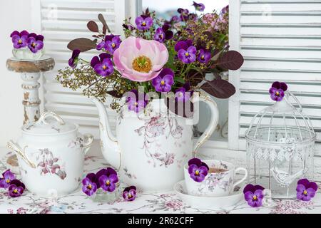 composizione con bouquet di fiori di peonia rosa e viola e porcellana d'annata Foto Stock