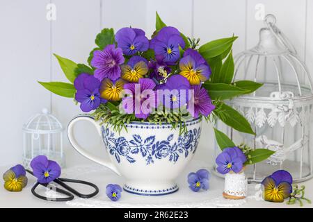 bouquet di fiori di viola blu e cranebill in tazza con ornamento floreale Foto Stock