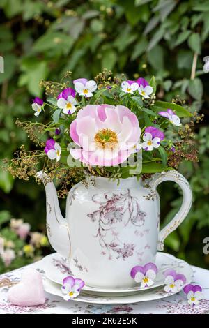 bouquet di fiori di peonia rosa e di viola in porcellana d'annata caffè lattina Foto Stock