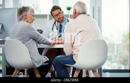 Prestare attenzione alle preoccupazioni dei pazienti. un medico che ha una consultazione con una coppia anziana in una clinica. Foto Stock