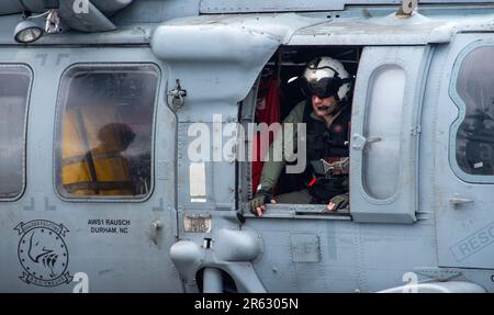 230601-N-JO823-1082 NORTH PACIFIC OCEAN (1 giugno 2023) Capo maggiore Naval Air Crewman (elicottero) Jesse Roberts, da Bath, Maine, siede in un falco marino MH-60s, attaccato ai Falconi d'oro di elicottero Sea Combat Squadron (HSC) 12, prima di una cerimonia di cambio di comando sul ponte di volo degli Stati Uniti L’unica portaerei della Marina schierata a termine, la USS Ronald Reagan (CVN 76), nell’Oceano Pacifico settentrionale, il 1 giugno 2023. Durante il cambio di comando, CMdR. Jonathan Dorsey fu sollevato dal CMdR. Seth Saalfeld come comandante di HSC 12. HSC 12, originariamente istituito come elicottero anti-sottomarino Foto Stock