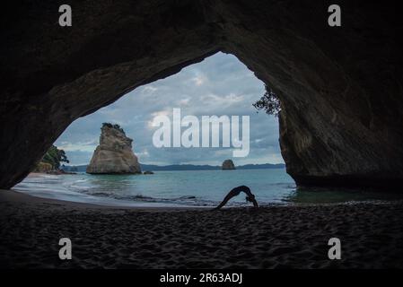 Un po 'di yoga / ponte posa in Cathedral Cove Foto Stock