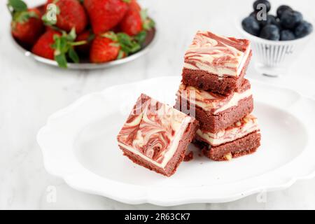 Brownie di formaggio con crema di velluto rosso a fette su piatto in ceramica bianca Foto Stock