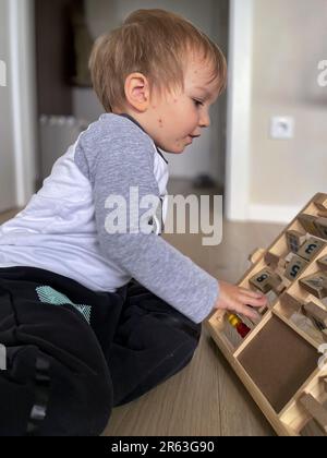Bambino piccolo con eruzioni di bolla di varicella che gioca sul pavimento Foto Stock