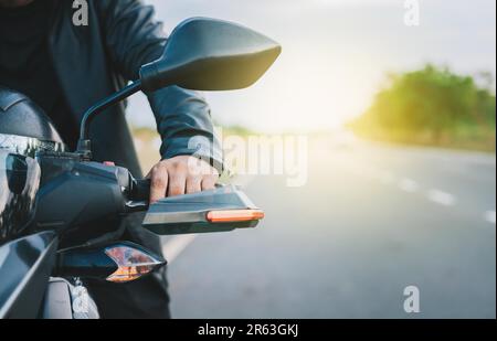 Mani di un motociclista sul manubrio della strada. Primo piano delle mani del motociclista sul manubrio di una motocicletta all'aperto. Moto velocità Foto Stock