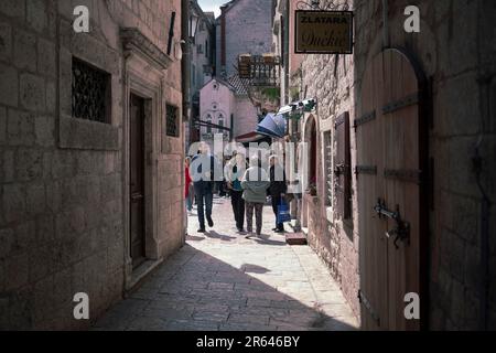 Cattaro, Montenegro, aprile 2023: Vista di una tipica stradina di ciottoli della città vecchia che termina sulla piazza della città Foto Stock