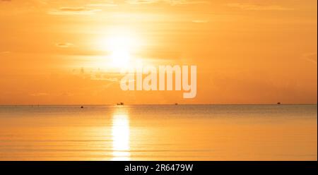 Alba d'oro, sole che sorge e riflesso del primo raggio che splende su cielo e mare. Foto Stock