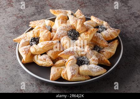 I Joulutorttu sono tradizionali crostate finlandesi di marmellata fatte e mangiate a Natale in un piatto su un tavolo. Orizzontale Foto Stock
