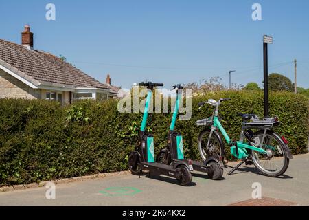 Bici elettrica beryl e scooter elettrici Beryl in un angolo di strada a Newport, Isola di Wight, disponibili a noleggio. Foto Stock