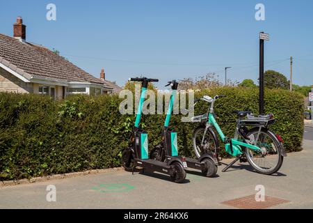 Bici elettrica beryl e scooter elettrici Beryl in un angolo di strada a Newport, Isola di Wight, disponibili a noleggio. Foto Stock