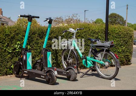 Bici elettrica beryl e scooter elettrici Beryl in un angolo di strada a Newport, Isola di Wight, disponibili a noleggio. Foto Stock