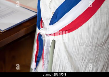 Donna francese città sindaco con sciarpa francia bandiera tricolore in abito bianco in celebrazione ufficiale in municipio Foto Stock