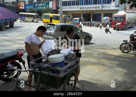 龙胜镇 (龙胜县) 中國 Longsheng, Cina; fornitore di cibo di strada; Vendedor ambulante de comida; Streetfood-Verkäufer; Uliczny sprzedawca posiłków; 街頭美食攤販 Foto Stock