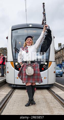 Edimburgo, Scozia, Regno Unito, 07 giugno 2023. Tram per Newhaven: Dopo 3,5 anni l'estensione della linea tranviaria della capitale è aperta ai passeggeri. I tram per Newhaven aggiungono 2,91 miglia di binario che collega Leith e Newhaven all'attuale estremità della linea del tram di Edimburgo a York Place con 8 nuove fermate. Nella foto: Piper Louise Marshall pipe nel primo tram a prendere i passeggeri da Picardy Place. Credit: Sally Anderson/Alamy Live News Foto Stock