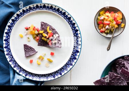Vista dall'alto verso il basso di una porzione di tortillas di mais blu con salsa fatta in casa. Foto Stock