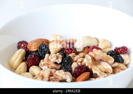 Primo piano di noci miste e frutta secca costituita da mandorle, noci, nocciole, anacardi, uva passa e mirtilli rossi con spazio copia sopra, sano Foto Stock