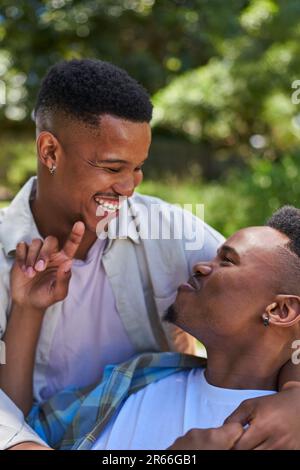 Felice, affettuosa giovane coppia gay maschio ridendo e abbracciando Foto Stock