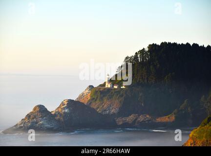 Ritratto al tramonto del faro di Heceta lungo la costa dell'Oregon. Foto Stock