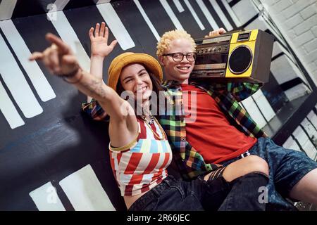 Ritratti giovani amici allegri che ascoltano musica con boom box Foto Stock