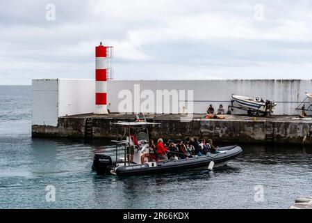 Porto Judeu, Portogallo - 3 luglio 2022: Zodiac barca gonfiabile con i turisti in arrivo in porto. Isola di Terceira, Azzorre Foto Stock