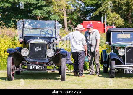 Due uomini anziani che parlano accanto alle loro auto classiche in Inghilterra, Regno Unito Foto Stock