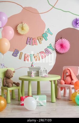 Interno per la festa di compleanno dei bambini con palloncini, giocattoli e mobili Foto Stock