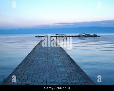 Barche in attesa al molo sul Lago Ohrid una mattina. Foto Stock