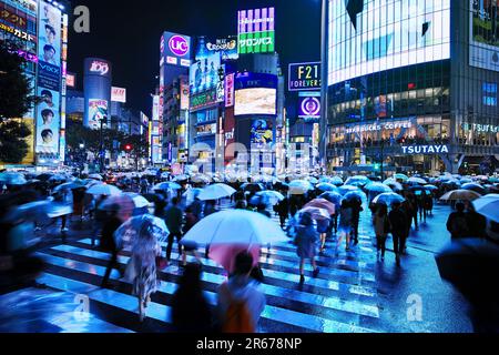 Shibuya Scramble Crossing affollato in una notte piovosa Foto Stock