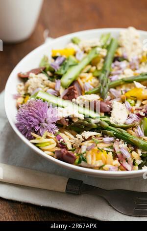 Ciotola con insalata di orzo fatta in casa con asparagi, fave e olive kalamata Foto Stock
