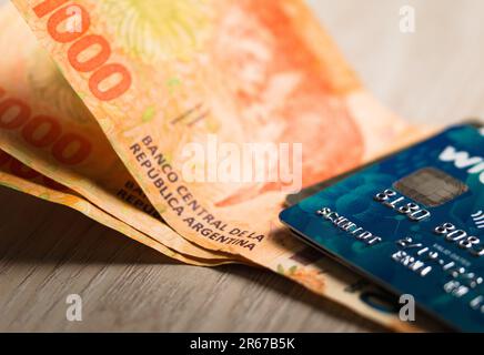 Carte di credito e alcune banconote argentine. Shopping online, concetto di finanze personali. Foto Stock