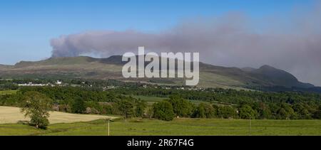 Killearn, Stirling, Scozia, Regno Unito. 7th giugno, 2023. Il servizio antincendio e di soccorso scozzese ha lanciato un avvertimento in tutta la Scozia riguardo a un rischio di incendio selvaggio "molto elevato". Nella foto: Nuvole di fumo da un fuoco selvatico che brucia sulle campsie Fells come visto sopra il villaggio di Killearn nel tardo pomeriggio. Scottish Fire and Rescue ha affermato che "a causa di un bombardamento in elicottero, consigliamo ai residenti locali di evitare l'area e di tenere chiuse le finestre e le porte". Credit: Kay Roxby/Alamy Live News Foto Stock