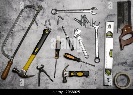 Un mazzo di chiavi e utensili su una superficie bianca e grigia Foto Stock
