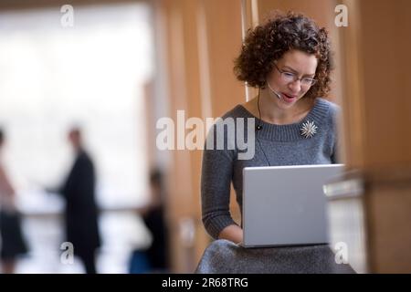 Donna che lavora da sola sul suo notebook all'aperto Foto Stock