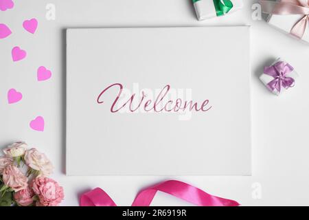 Carta di benvenuto. Tela con parola, scatole regalo, belle rose, cuori rosa e nastro su sfondo bianco, piatto Foto Stock