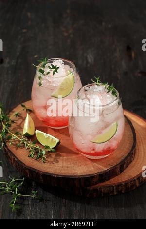 Lemonade fredda di frutti di bosco rossi fatti in casa con timo e ghiaccio tritato, bevanda fresca estiva Foto Stock