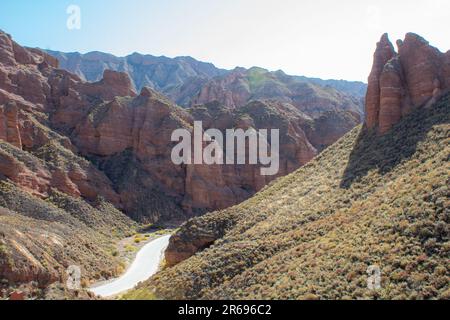 Vista aerea di Danxia Binggou Canyon rilievi in Zhangye, Sunan Regione, Provincia di Gansu, Cina. Sharp picchi appuntiti nel Geoparco. Strada a valle su un Foto Stock