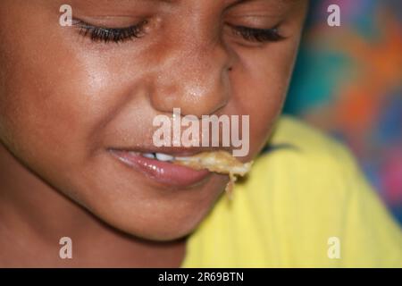 Il bambino indiano sta mangiando palle d'acqua Foto Stock